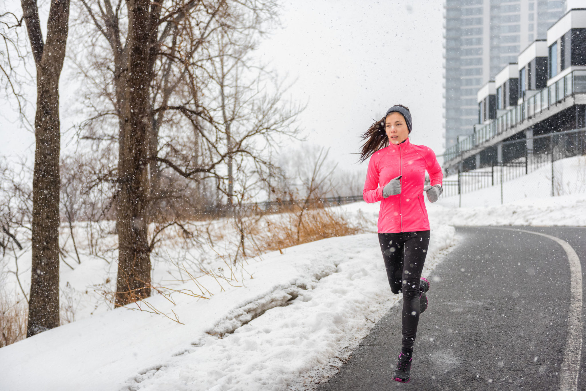 Winter running Asian girl wearing cold weather clothing for outside