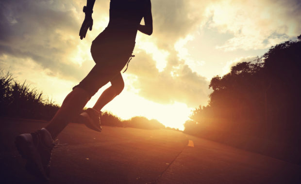 Runner athlete running at seaside road. woman fitness silhouette sunrise jogging